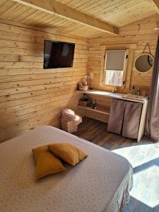 sypialnia z łóżkiem w drewnianym domku w obiekcie LAlexandrie w mieście Régusse