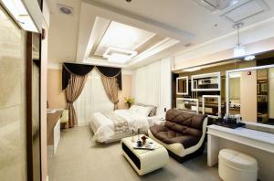 Habitación de hotel con cama y sofá en Gentleman Hotel en Suncheon