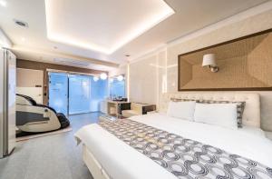 una camera d'albergo con un grande letto e una scrivania di Gentleman Hotel a Suncheon