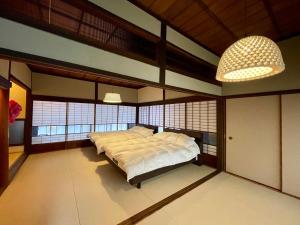 1 dormitorio con 1 cama en una habitación con ventanas en YudaOnsen Byakkoan　山口湯田温泉 白狐庵, en Yamaguchi
