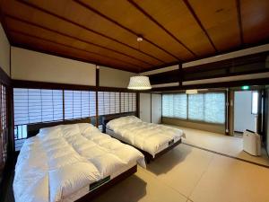 山口YudaOnsen Byakkoan　山口湯田温泉 白狐庵的有两张床和天花板的卧室