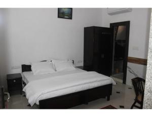 齋浦爾的住宿－"Boby Homestay", Boby Mansion, Jaipur，卧室内的一张带白色床单和枕头的床