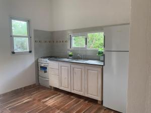 uma cozinha com um frigorífico branco e um lavatório em Los 4 elementos em San Marcos Sierras