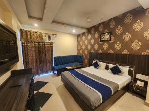 una camera con un letto e un divano blu di Hotel Savera a Udaipur