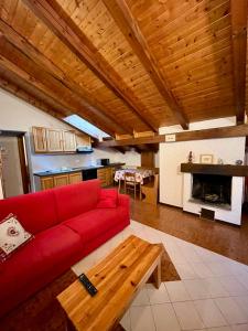 sala de estar con sofá rojo y mesa en Val di Sole Apartment, en Monclassico