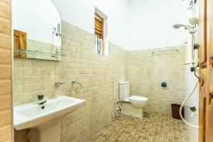 a bathroom with a sink and a toilet at Hari Hari Arugambay in Arugam Bay