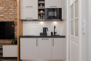 Beautiful & Stylish Apartaments Dietla with Air Conditioning by Renters في كراكوف: مطبخ مع دواليب بيضاء وميكرويف