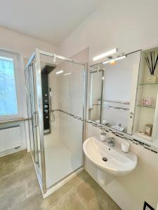 uma casa de banho branca com um chuveiro e um lavatório. em Margherita Apartment em Malcesine