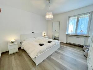 um quarto branco com uma cama grande e um espelho em Margherita Apartment em Malcesine