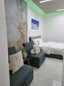 - un salon avec un lit, un canapé et une chaise dans l'établissement Appartamento Crihana, à Aoste