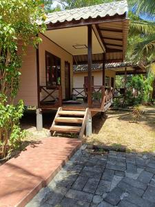 Cette petite maison dispose d'une terrasse couverte et d'un escalier en bois. dans l'établissement Mangrove House Kohyao noi, à Ban Bang Chak