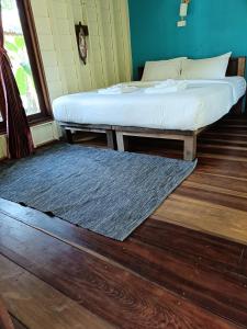 - une chambre avec 2 lits et un tapis au sol dans l'établissement Mangrove House Kohyao noi, à Ban Bang Chak