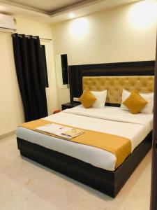 a bedroom with a large bed with yellow pillows at Hotel IBY in New Delhi