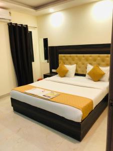 ein Schlafzimmer mit einem großen Bett mit gelben Kissen in der Unterkunft Hotel IBY in Neu-Delhi