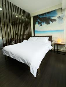 1 dormitorio con 1 cama blanca grande y una pintura en la pared en Private Studio in Gramercy, Poblacion, en Manila