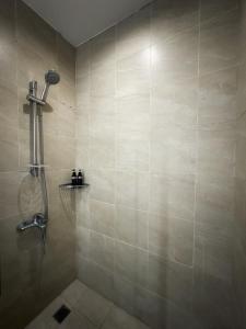 y baño con ducha y pared de azulejos. en Private Studio in Gramercy, Poblacion, en Manila