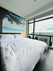 1 dormitorio con cama blanca y ventana grande en Private Studio in Gramercy, Poblacion, en Manila