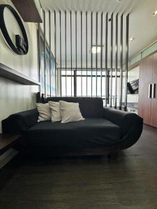Sofá negro con 2 almohadas en una habitación en Private Studio in Gramercy, Poblacion, en Manila
