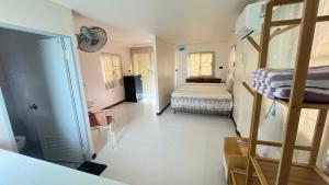 a bedroom with a bed and a bunk bed at Aiem-Wilai Guesthouse in Surat Thani