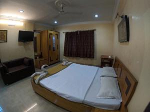 1 dormitorio con 1 cama grande y 1 sofá en Hotel Sarita Resort en Jajpur Road