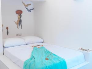 a white bed with a blue bag on it at Blue and White Aura Santorini traditional house in Megalochori