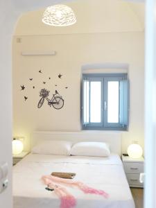 a bedroom with a bed with a bike on the wall at Blue and White Aura Santorini traditional house in Megalochori