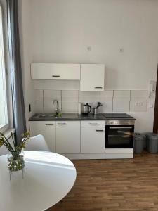 a kitchen with white appliances and a white table at Villa Rathenow in Rathenow