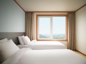 Postel nebo postele na pokoji v ubytování Gyeongju Mauna Ocean Resort