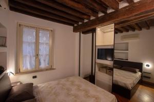 a bedroom with a bed and a tv and a window at Carlo & Dany Piano Terra in centro con giardino in Parma
