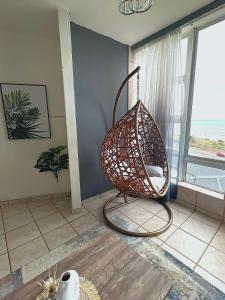 a wicker chair in a room with a large window at Beach View in Scottburgh