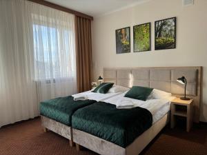 a bedroom with a large bed with a green blanket at Załęże in Katowice