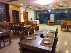 Hotel Brij Palace & Restaurant في أودايبور: غرفة طعام كبيرة مع طاولة وكراسي طويلة