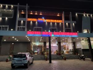 een auto die 's nachts voor een hotel geparkeerd staat bij Hotel Brij Palace & Restaurant in Udaipur