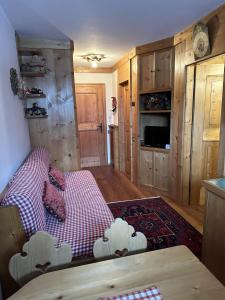 a room with a bed with a red and white blanket at Pecol Cozy Apartment R&R in Cortina dʼAmpezzo