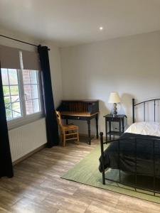 a bedroom with a bed and a table and a desk at L'Oreade in Amfreville-sur-Iton