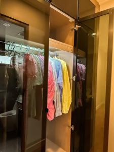 曼谷的住宿－summer villa 曼谷中心Asok&Thong Lor800平米海天别墅189/7，一个带玻璃门和一些衣服的衣柜