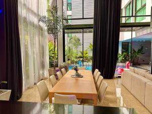 summer villa 曼谷中心Asok&Thong Lor800平米海天别墅189/7 في بانكوك: غرفة طعام مع طاولة وكراسي ونافذة كبيرة