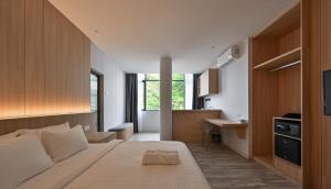 a bedroom with a large bed and a kitchen at Macalister 288 in George Town