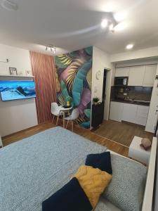 a living room with a large bed and a kitchen at Apartman Luxor in Jagodina