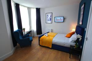 ein Schlafzimmer mit einem Bett und einem blauen Stuhl in der Unterkunft St David in Barrow in Furness