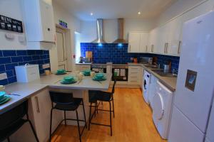 uma cozinha com mesa, cadeiras e azulejos azuis em St David em Barrow in Furness