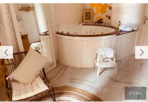 uma casa de banho com uma banheira, uma cadeira e um banco em New Suite & SPA - Cannes Centre - Croisette em Cannes