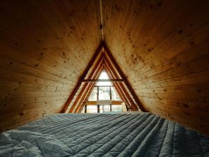 a bedroom with a bed in a room with a window at A Frame Cabin - Valea Vinului in Vişeu de Mijloc +21 photos