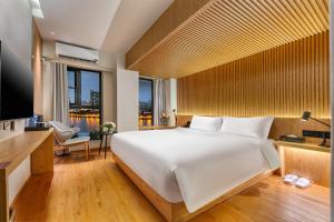 a bedroom with a large white bed and a desk at MARHAUS Hotel Beijing Road Tian-Zi Pier Store in Guangzhou