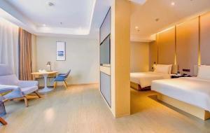 a hotel room with two beds and a desk at Atour Hotel Guangzhou Huadu Financial Center in Huadu
