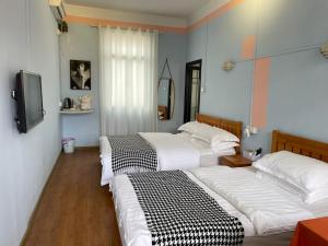 a bedroom with two beds and a tv in it at Changsha Fuxiangyuan International Hostel in Changsha