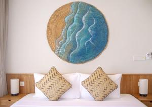 Stone Beach Club في ديفوشي: لوحة معلقة على جدار فوق سرير مع الوسائد
