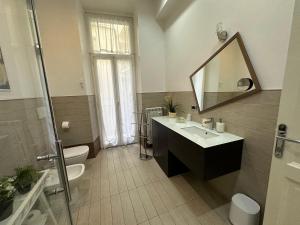 łazienka z umywalką, toaletą i lustrem w obiekcie Rome Holiday Home w Rzymie