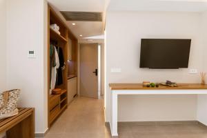 a room with a desk with a tv on the wall at Sofibel sivota suites in Syvota