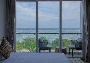 a bedroom with a large window with a view of the ocean at Stone Beach Club in Dhiffushi